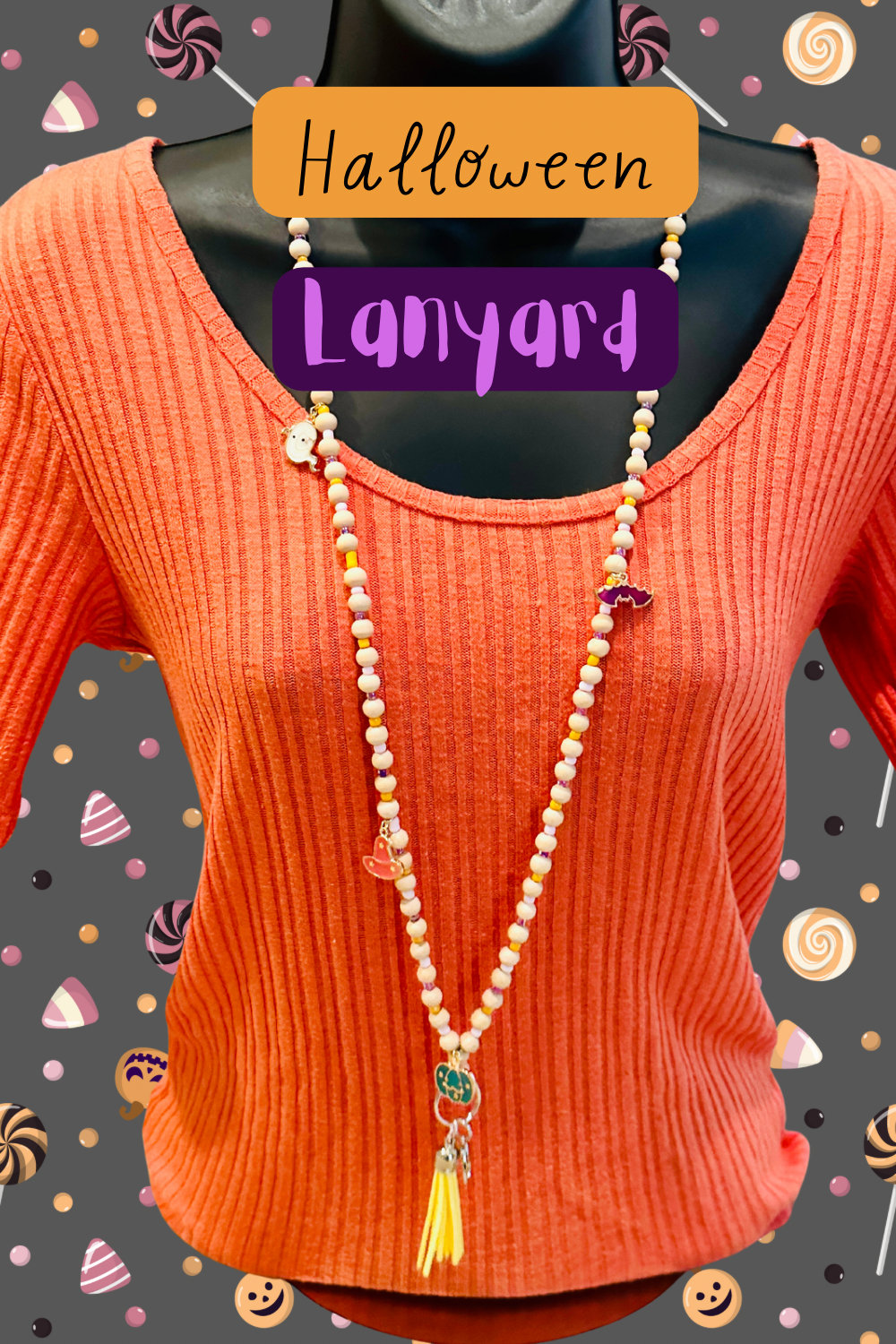 The Halloween Lanyard on a mannequin wearing an orange sweater.  The background is grey with images of candy.