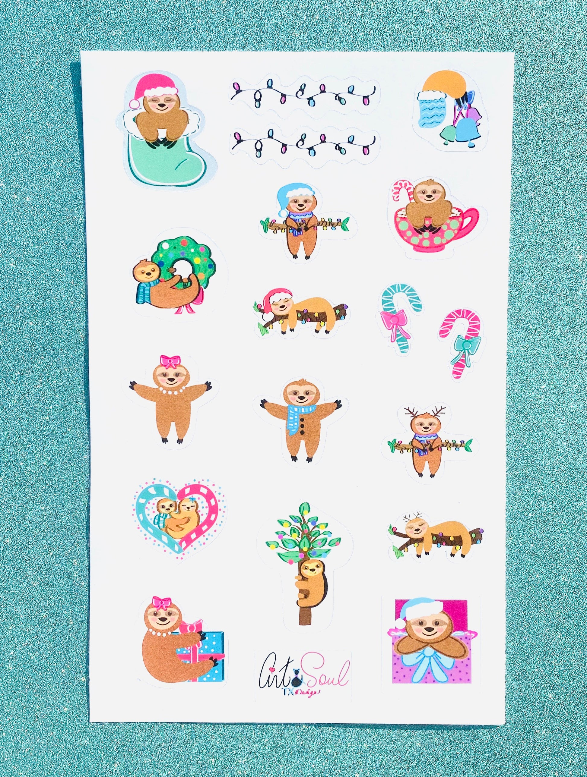 The Sloth Christmas sticker sheet on a shiny blue background with glitter.